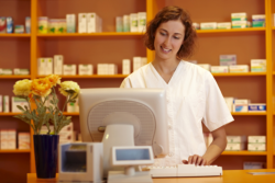 Pharmacist is registering the price of the medicine